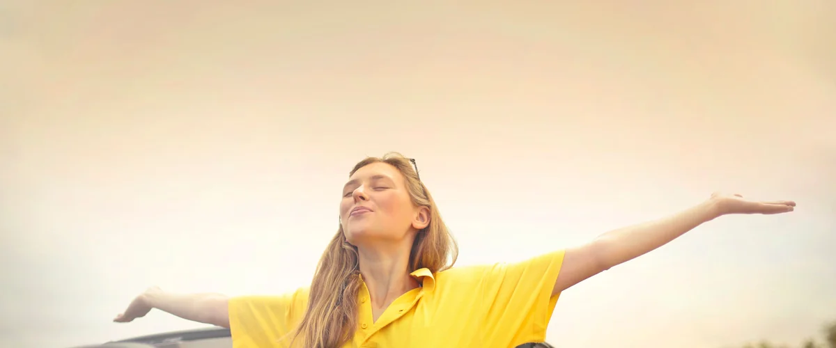 Woman arms outstretched feeling financial freedom — relief after paying off OppLoans loan